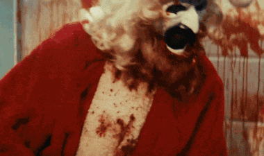 a close up of a person dressed as santa claus with blood on his shirt .