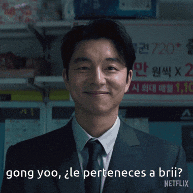 a man in a suit and tie is smiling and says " gong yoo "