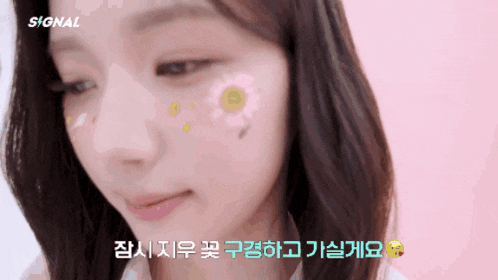 a close up of a woman 's face with flowers on her face and the word signal on the bottom right