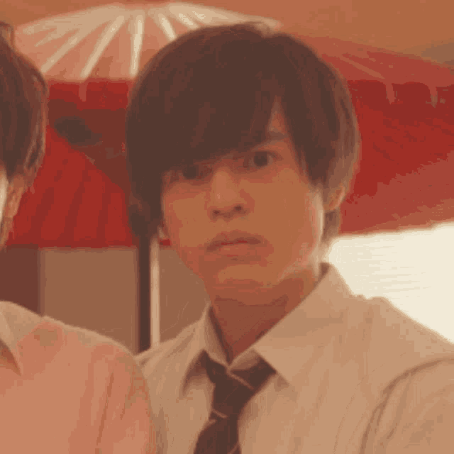 a man in a tie is making a surprised face .
