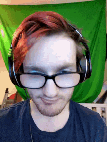 a man wearing glasses and headphones is smiling in front of a green background