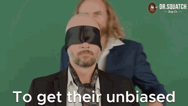 a man in a suit and tie is blindfolded with the words to get their unbiased above him