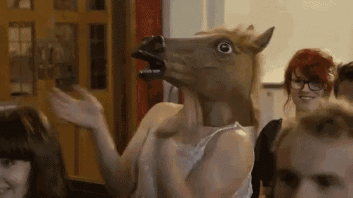 a woman wearing a horse mask is dancing in a crowd .