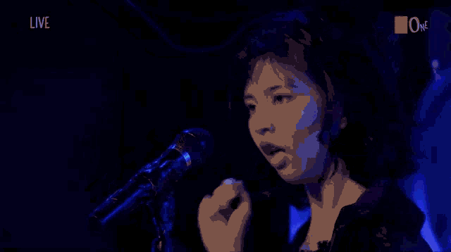a woman is dancing in front of a screen that says live on it