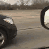 a car is driving down a highway next to another car .