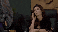 a woman sitting at a desk talking on a phone