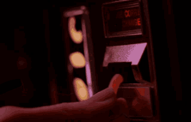 a person 's hand is reaching out in the dark