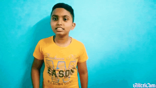 a young boy wearing a yellow t-shirt with the word season on it