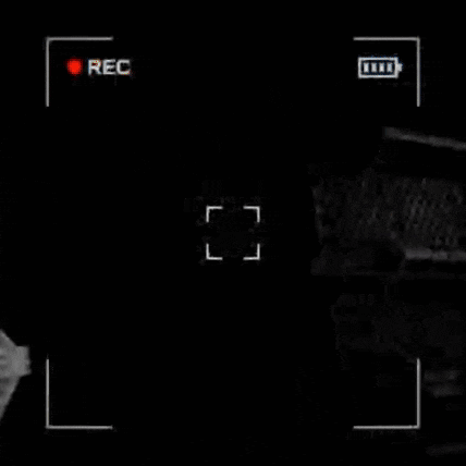 a person in a gas mask is walking in a dark room .
