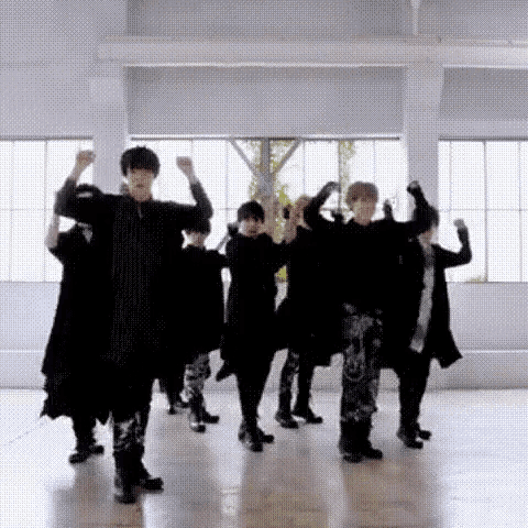a group of people are dancing in a room in front of a window .