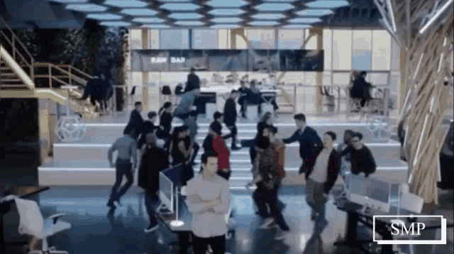 a group of people are dancing in a room with a sign that says raw bar