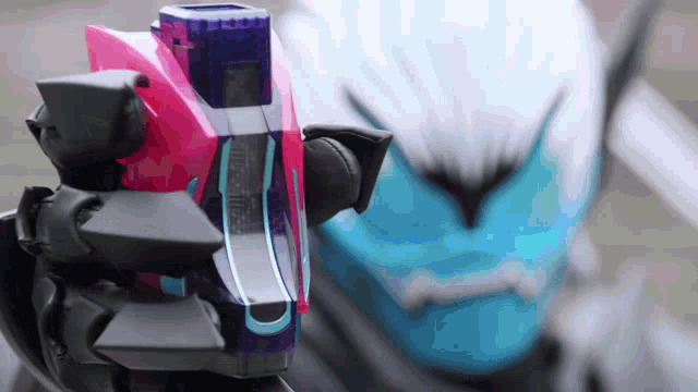 a person with a blue mask is holding a pink and blue object