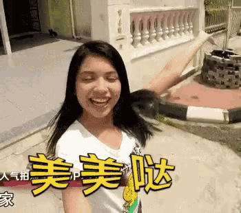 a woman is smiling in front of a building with chinese writing on it