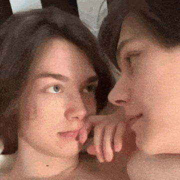 a man and a woman are touching each other 's noses and looking at each other .