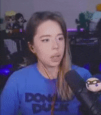 a woman is talking into a microphone while wearing headphones and a blue shirt .