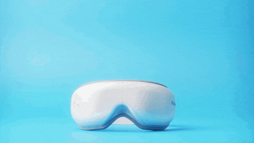 a black and white renpho eye massager on a blue surface