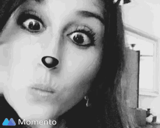 a woman is making a funny face with a dog nose .