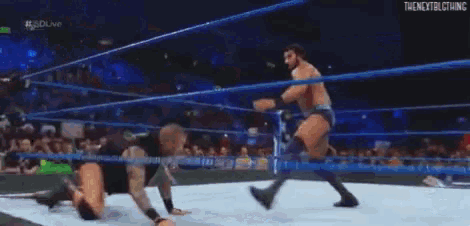 two men are wrestling in a wrestling ring in front of a crowd of people .