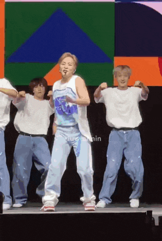 a group of people are dancing on a stage with the word nin visible in the corner