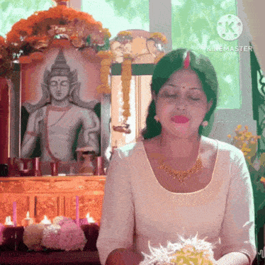 a woman in front of a picture of a buddha with the words kinemaster on the bottom