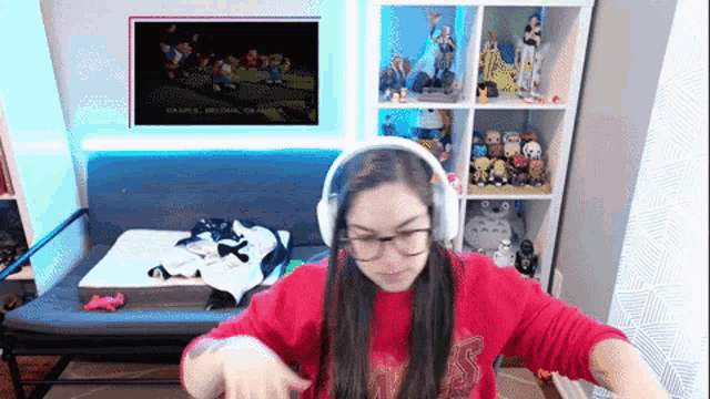 a woman wearing headphones and a red shirt that says ' nintendo ' on it is playing a video game