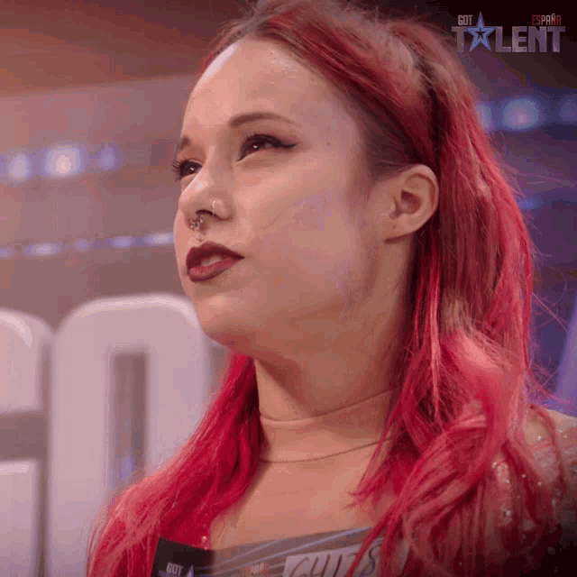 a woman with red hair is standing in front of a sign that says " got talent "
