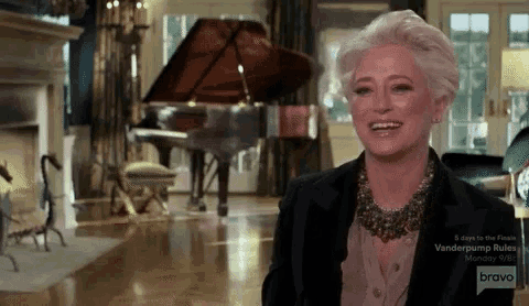 a woman is smiling in a room with a piano in the background