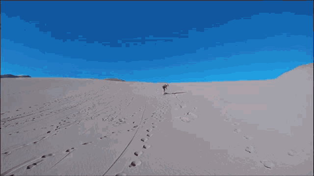 a woman is reaching out to a man in the sand