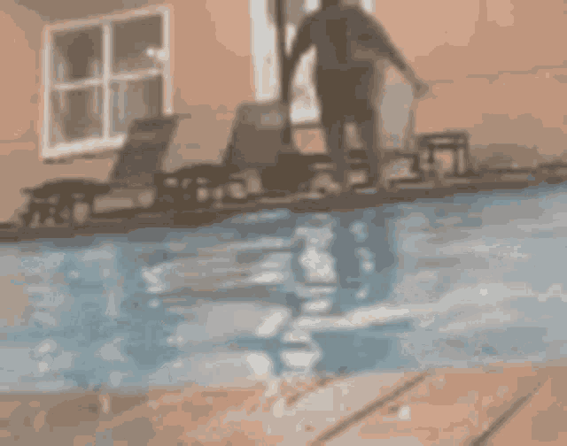 a man is jumping into a swimming pool in front of a building .