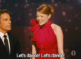 a woman in a red dress is dancing with a man in a suit and tie