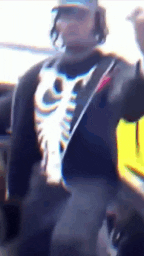a blurry picture of a man wearing a skeleton shirt and hat