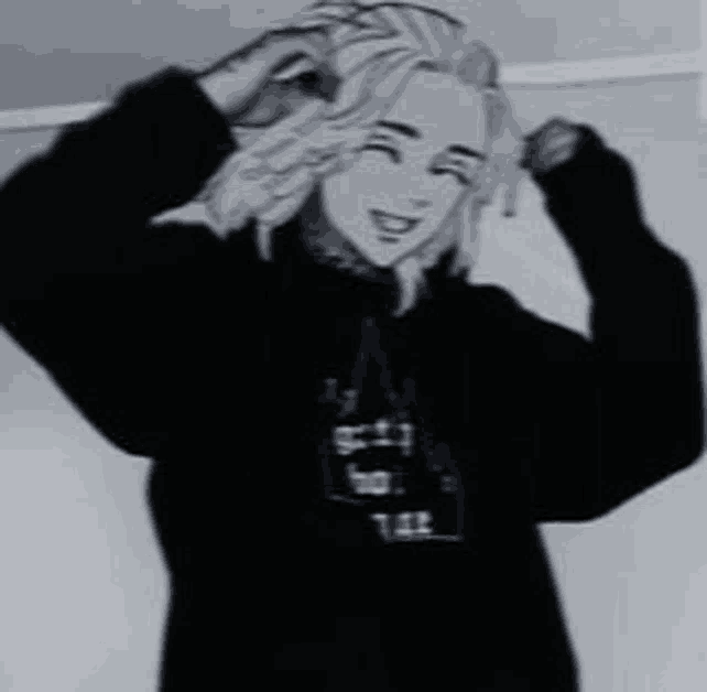 a black and white photo of a man wearing a black hoodie .