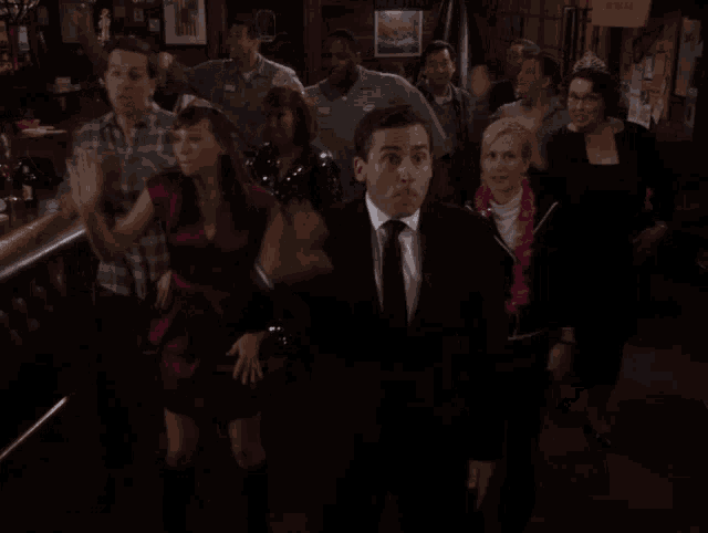 a group of people are dancing in a dark room with a sign that says ' beer ' on it