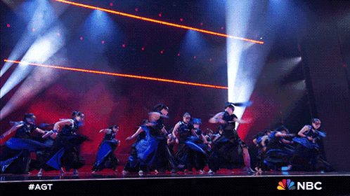 a group of people dancing on a stage with a nbc logo
