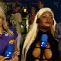 a woman with blonde hair is wearing a black top with a blue bottle around her neck