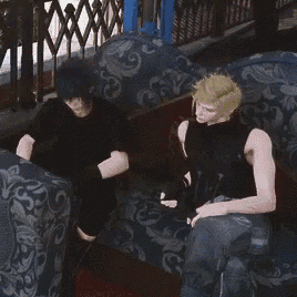 two men are sitting on a couch talking to each other .