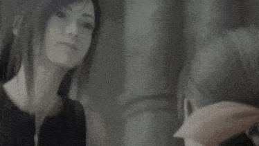 a black and white photo of a woman looking at herself in the mirror