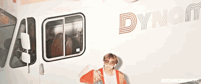 a man is standing in front of a white truck that says dynamite