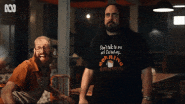 a man with long hair and a beard is wearing a morning brown shirt