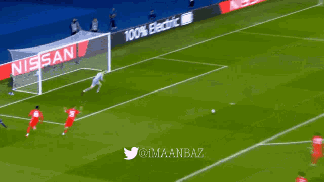 a soccer game is being played on a field with a nissan banner