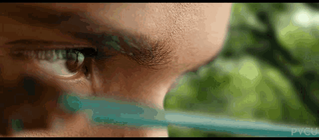 a close up of a man 's eye with a green light coming out of it ..