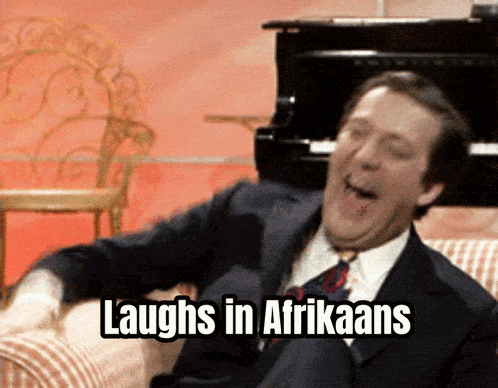 a man in a suit and tie is laughing with the words laughs in afrikaans below him
