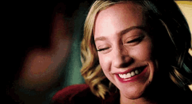 a close up of a woman 's face with her eyes closed and smiling .