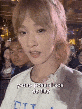 a woman with blonde hair is wearing a white t-shirt that says eli on it