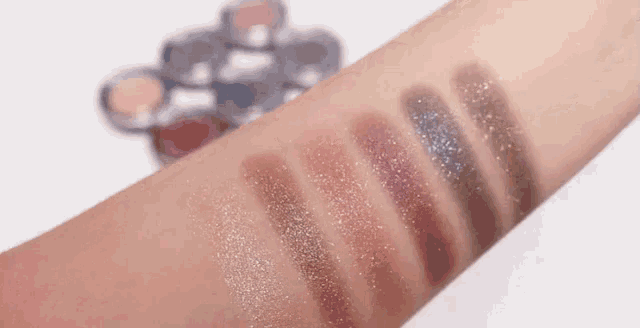 a close up of a woman 's arm with a palette of eye shadows on it .