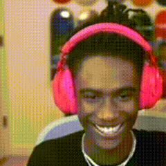 a man wearing pink headphones is smiling in a blurry photo