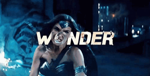 wonder woman is standing in front of the word wonder on a dark background .