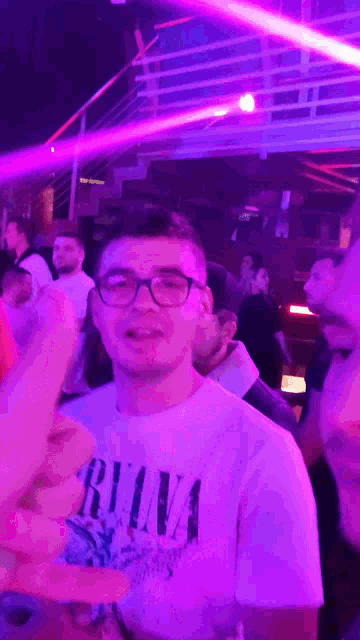 a man wearing a shirt that says nirvana stands in a crowd