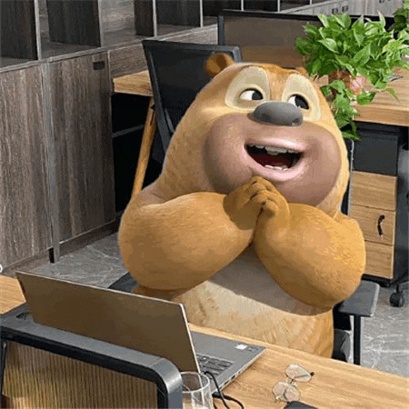 a teddy bear is sitting at a desk with a laptop .