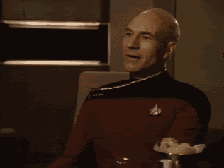 a man in a star trek uniform is clapping his hands and smiling